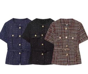 Dettaglio della trama in tweed e bottoni metallici su giacche a maniche corte eleganti