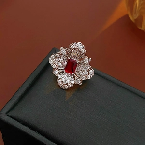 Macro shot of silver flower ring featuring a red rectangular gemstone and zircons