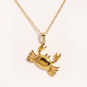 Nahaufnahme einer goldenen Edelstahl-Halskette mit Krabbenanhänger und poliertem Finish