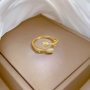 Macro shot of gold tulip ring with diamonds in a jewelry box on white silk fabric