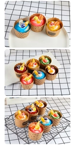 Detailed view of assorted artificial cupcakes with fruit toppings on a checkered cloth