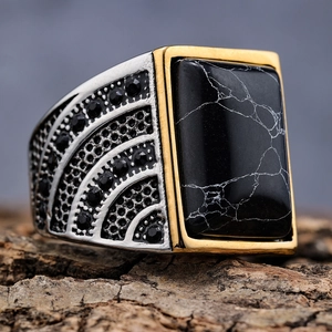Vintage men's stainless steel ring with black marble stone and gold accents on wood bark