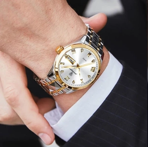 Close-up of men's two-tone luxury watch with white dial and dual calendar display window