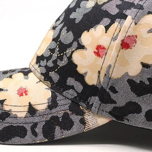 Detailed close-up of floral denim cap showing premium gold thread embroidery and fabric