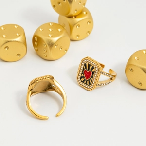 Détails macro de bagues dorées avec cœurs en émail rouge et strass brillants