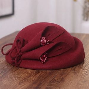 Elegant wine red wool felt pillbox hat with 3D floral accent on wooden surface