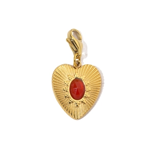 Close-up of gold heart pendant featuring a red oval gemstone and lobster clasp detail