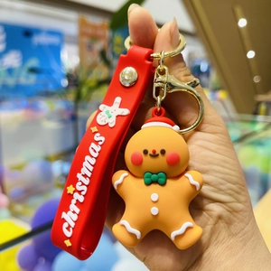 Close-up of a gingerbread man keychain with red Christmas strap and silicone texture