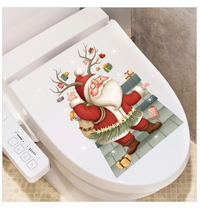 Detail of Christmas Santa and reindeer stickers on a white toilet lid for bathroom decor