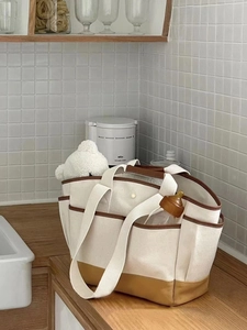 Detail of canvas diaper bag with leather trim and pockets for bottles and toys