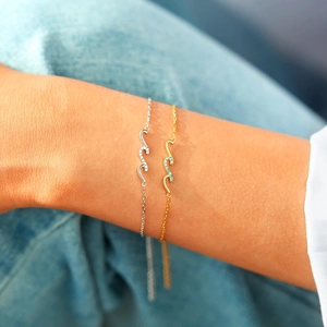 Gros plan sur des bracelets vagues minimalistes en or et argent avec des zircons