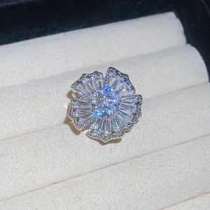 Macro shot of a floral silver earring featuring sparkling zircons and a central pearl accent