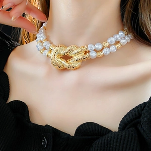 Close-up of double-layer pearl necklace with a vintage golden knotted metal clasp