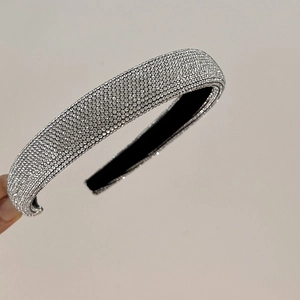 Close-up of sparkling full rhinestone headband with thick silver padding and black lining
