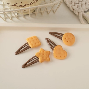 Detailed view of four cookie-shaped hair clips including heart and star resin designs
