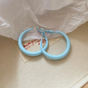 Detailed top view of blue glossy hoop earrings with minimalist circular design style