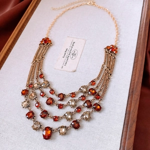 Close-up of vintage multi-layer gold chain necklace with amber crystals and retro gems