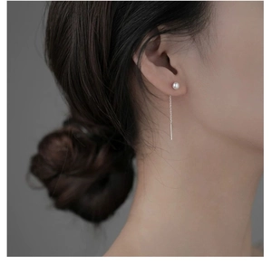 Gros plan détaillé d'une femme portant des boucles d'oreilles pendantes en argent S925