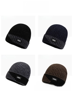 Detail view of knitted beanies in black, navy, grey, and coffee colors with GD logo