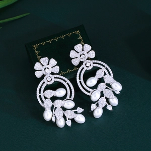 Luxurious flower pearl drop earrings with sparkling cubic zirconia on a green box