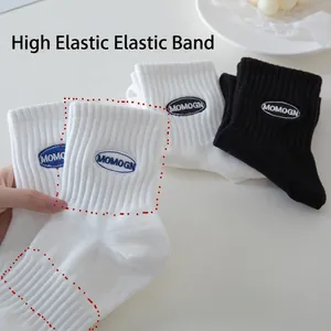White and black cotton crew socks with MOMOGN embroidery and elastic ribbed cuffs