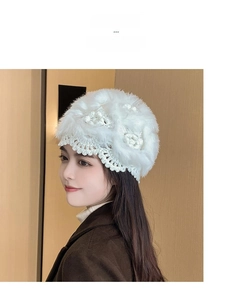 Detail of white handmade crochet knit beanie with soft fur texture and floral design