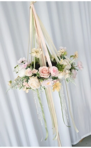 Close-up of floral hanging decoration with pink roses, colorful ribbons and crystal beads