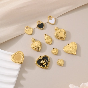 Detailed close-up of golden stainless steel heart charms with enamel and tree of life motifs