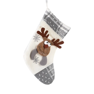 Knitted Christmas stocking with 3D reindeer decor and grey plaid trim hanging on white backdrop