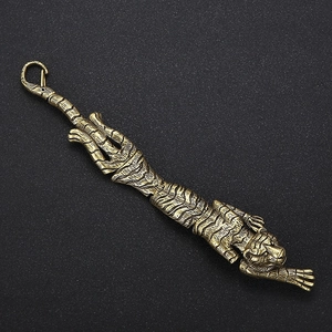 Detailed macro view of an articulated tiger bracelet in vintage gold finish on black background
