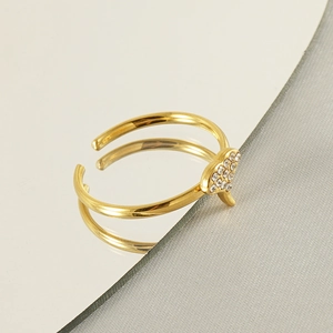Close-up of golden 18k ginkgo leaf ring with sparkling diamonds on a mirror reflection