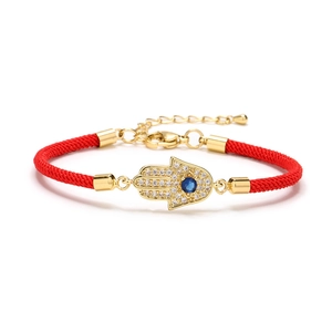 Adjustable red braided Hamsa Hand bracelet with gold plating and blue cubic zirconia center