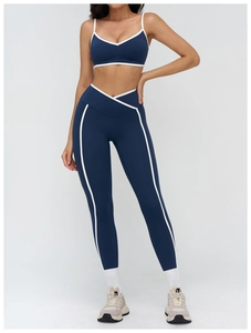 Detail of navy blue yoga bra with white piping and high-waisted cross V-belt leggings