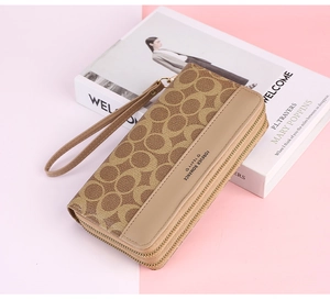 Detailed close-up of long zip-around wallet with classic monogram pattern and wrist strap