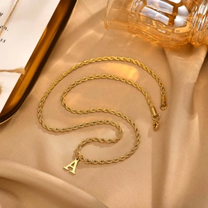 Detail of gold-plated stainless steel twisted rope chain with a large letter A pendant
