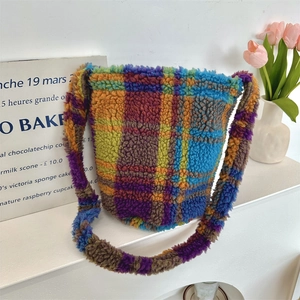 Colorful plaid plush tote bag with fuzzy texture on a stylish white shelf with tulips