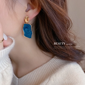 Orecchini retrò blu irregolari con accenti dorati indossati sul profilo