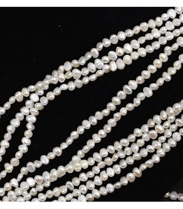 Macro detail of natural white baroque pearls with lustrous finish on black background