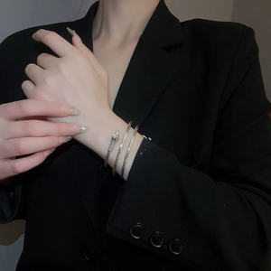 Detailed close-up of a silver snake wrap bracelet with textured scales and rhinestone eyes