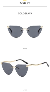 Detail view of gold-black rimless cat eye sunglasses with wavy metal temples
