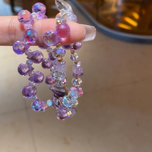 Macro detail of purple iridescent faceted crystal beads on multi-layer bracelet with gold spacers