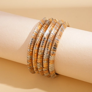 Detail of a two-tone geometric metal multi-layer bracelet set on a display stand