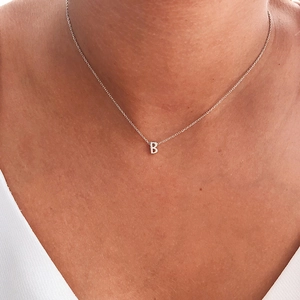 Close-up of 925 sterling silver chain with a polished letter B pendant on neck