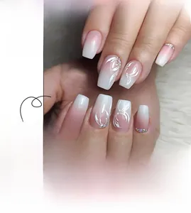 Detail of short ombre nails with pink white gradient, flower petals and rhinestones