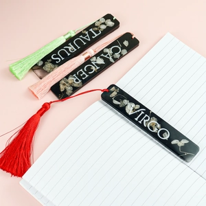 Marque-pages DIY en résine avec constellations, fleurs séchées et pompons colorés