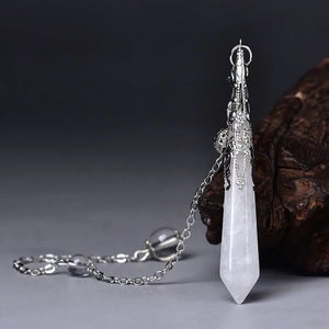 Detailed close-up of white quartz hexagonal crystal pendulum with vintage silver metal cap