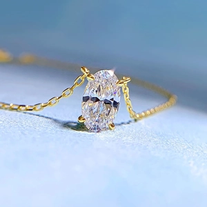 Macro detail of oval cut diamond pendant on a gold chain with four-prong setting