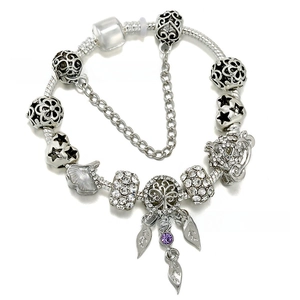Detail view of silver snake chain bracelet with purple gems and life tree charms