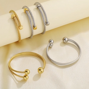 Detailed view of punk cable wire cuff bracelet with twisted texture and spherical end caps