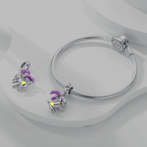 Silver snake chain bracelet featuring purple goat zodiac charms and star details